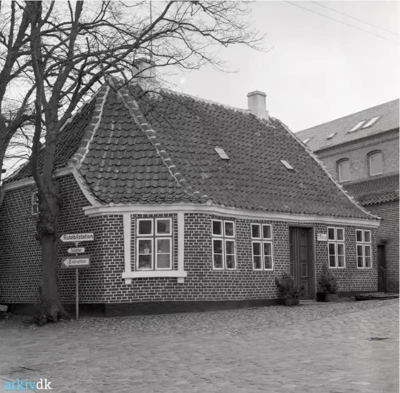 Sillasens Hus med skiltet "Rutebilstation" ved indgangen til gårdspladsen, ca. 1973