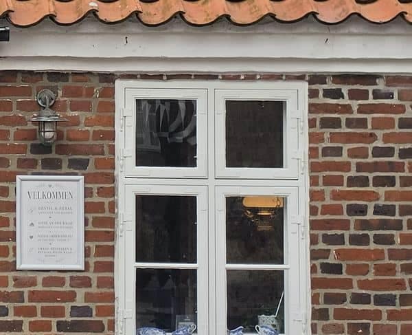 Rød blank mur, hvidkalket gesims og hvidt vindue